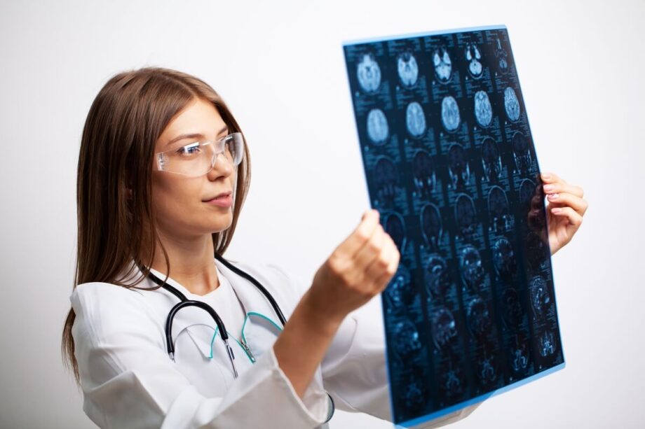 Neurolog ogląda szczegółowo skan mózgu.