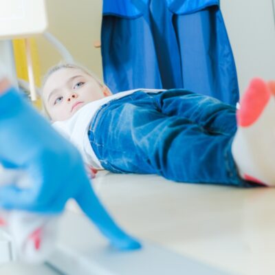 Małe dziecko w gabinecie pediatrycznym leży na stole podczas badania.